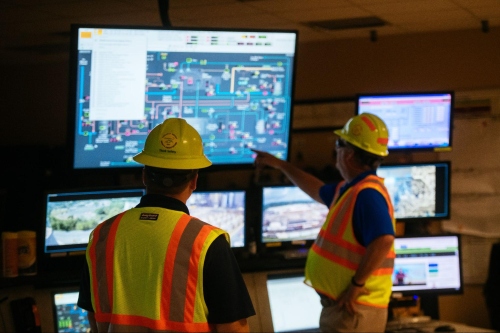 two workers viewing a systems screen